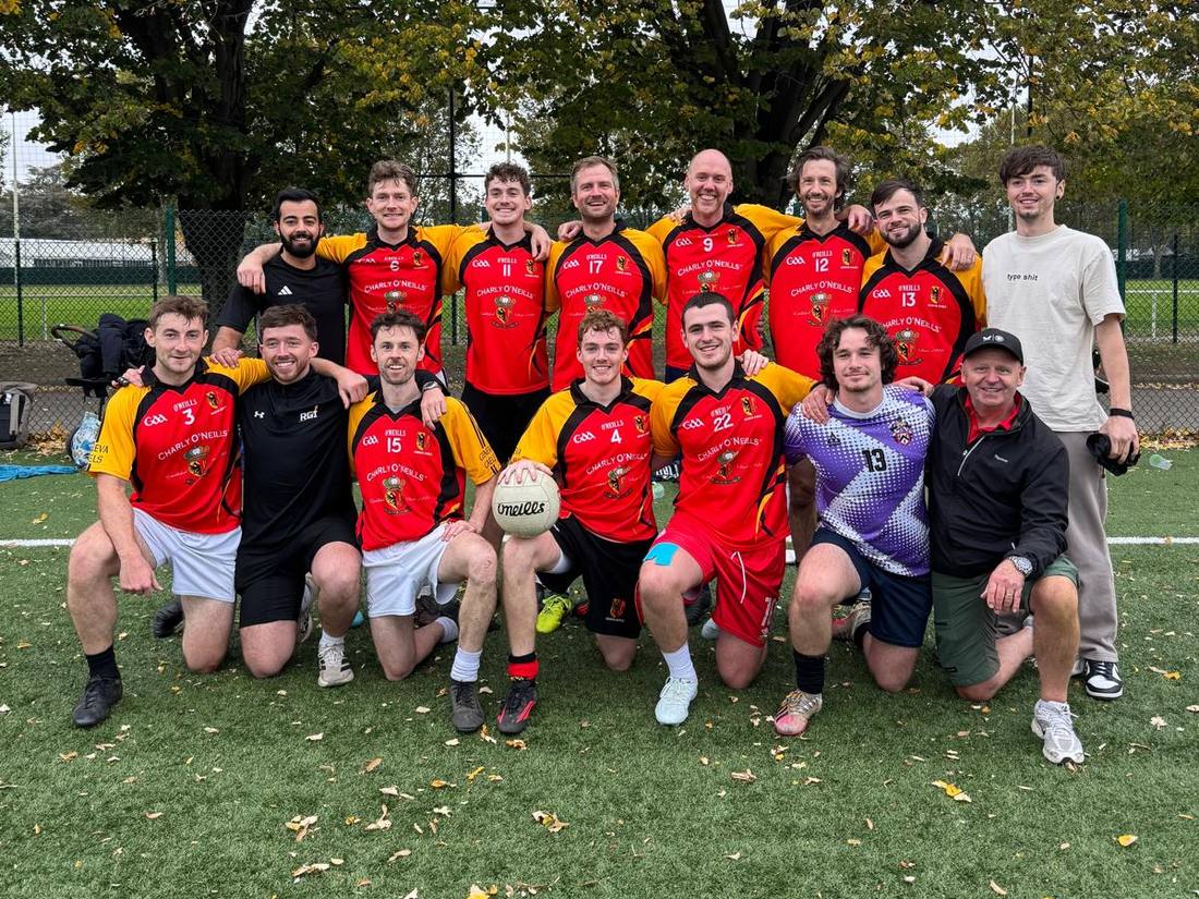 The full Geneva Gaels squad in red and gold jerseys, posing on the pitch